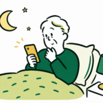 夜、布団の中でスマートフォンを操作する高齢の男性。